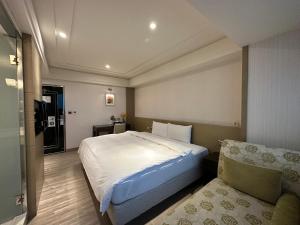 台北的住宿－世聯商旅，一间卧室配有一张大床和一张沙发