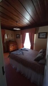 拉梅戈的住宿－Casa do Lobo，一间卧室设有一张带木制天花板的大床