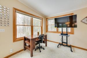 una oficina con escritorio y TV de pantalla plana en Cheboygan Getaway with Fire Pit and Lake Access!, en High Banks