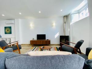 a living room with a blue couch and chairs at Tia Anica House I - apartment with terrace in central Fuseta beach village in Fuzeta