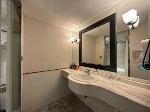 a bathroom with a sink and a large mirror at Link World Hotel in Taipei
