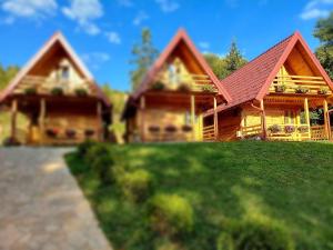 une grande maison en bois avec un toit rouge dans l'établissement Drveni raj Uvac, à Sjenica