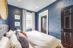 a bedroom with blue walls and a bed with pillows at Luxury 8 Bed/4 Ba NuLu Home Private yard/parking in Louisville