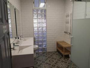 a white bathroom with a sink and a toilet at Hostal del Arquitecto in Vitoria-Gasteiz