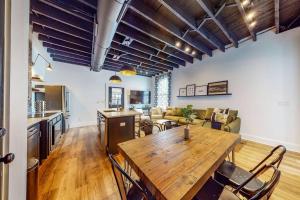 a living room with a wooden table and a couch at Luxury 8 Bed/4 Ba NuLu Home Private yard/parking in Louisville