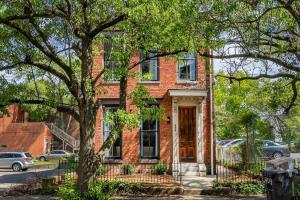 a brick house with a tree in front of it at Luxury 8 Bed/4 Ba NuLu Home Private yard/parking in Louisville