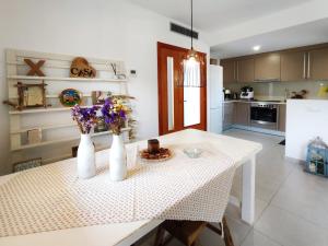 una cucina con tavolo e fiori in vaso di Casa con piscina en L'Estartit a Girona
