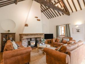 a living room with leather furniture and a fireplace at Ty Bont in Wrexham