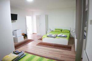 sypialnia z łóżkiem z zielonym kocem w obiekcie Rooms Busujok w mieście Kladovo
