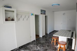 a kitchen with a table and two stools in a room at Rooms Busujok in Kladovo