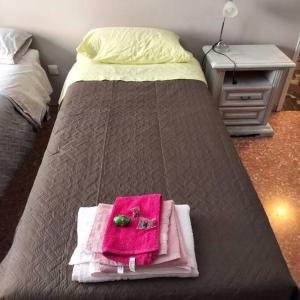 a bed with a pink towel on top of it at Daniele's flat in Venice Mestre in Mestre