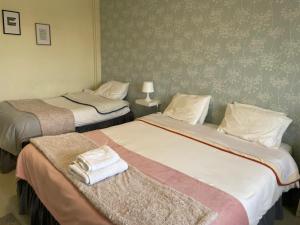 twee bedden in een hotelkamer met handdoeken erop bij Liber Guest House in Braga
