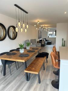 a dining room with a table and a living room at Outstanding 5 Bedroom Townhouse, Canal Views By Valore Property Services in Milton Keynes