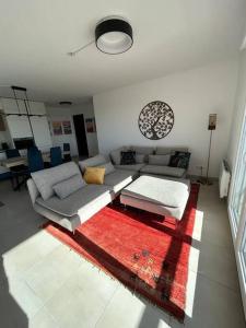 a living room with a couch and a red rug at Superbe appartement 3 chambres à Grasse in Grasse