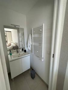 a white bathroom with a sink and a mirror at Superbe appartement 3 chambres à Grasse in Grasse