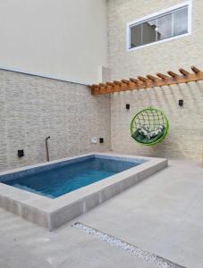 a swimming pool in front of a building at Casa com Píer à Beira do Rio Preguiças em Condomínio Fechado in Barreirinhas