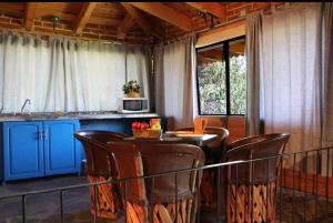 - une cuisine avec une table et des chaises dans la chambre dans l'établissement Hotel Bugamvillas Tapalpa extensión, à Tapalpa