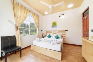 a bedroom with a bed and a chair at Sevinex Inn in Feridhoo