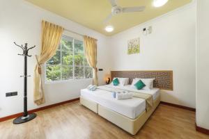 a bedroom with two beds and a window at Sevinex Inn in Feridhoo