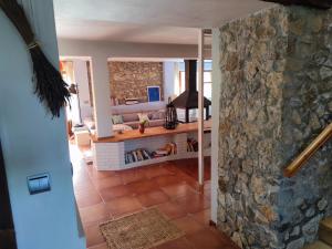 vistas a una sala de estar con una pared de piedra en Mote Cottage, en Mutriku