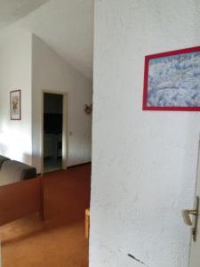 a room with a white wall with a painting on the wall at Alberti - Condominio La Zangola in Madonna di Campiglio