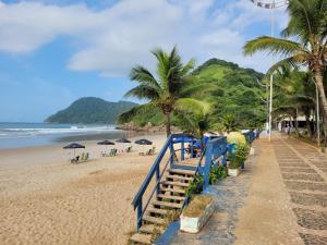 uma escada azul que leva a uma praia com palmeiras em Praia do Tombo no Guarujá