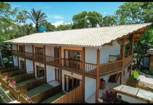 a house with a wooden roof and a balcony at Flat Vila Taipu in Marau