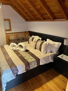 una camera da letto con un letto con cuscini sopra di Waves Song - Cottage a Porto Moniz