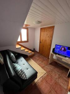 a living room with a couch and a flat screen tv at Waves Song - Cottage in Porto Moniz