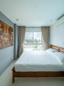 a bedroom with a large bed and a large window at Mae Phim Grand Blue Condo 508 with pool and seaview in Mae Pim