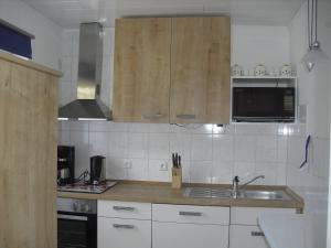 a kitchen with wooden cabinets and a sink at Haus Weiche in Flensburg