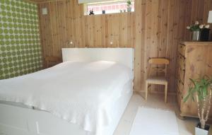 1 dormitorio con 1 cama blanca y 1 silla en Holiday Home Vrigstad with Lake View 02 en Vrigstad
