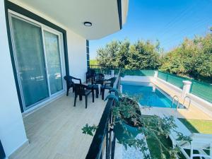 a balcony with a table and chairs and a swimming pool at Villa Cennet Dalaman 11 in Dalaman