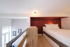 a bedroom with a bed with a wooden headboard at Studios with city view in Brussels