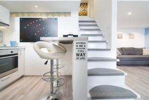 a living room with a staircase with a chair and a sign at happy home BLUE - apartment with free Pinball Machine in Budapest