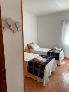 um quarto com 2 camas e um espelho em LA CALDERETA CASA RURAL em La Oliva