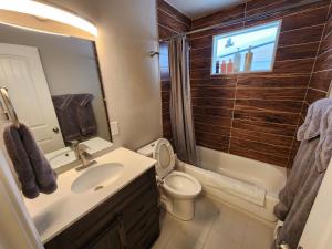 a bathroom with a sink and a toilet and a tub at Nightshade BnB in Anchorage