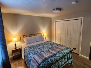 a bedroom with a bed and two lamps and a door at Nightshade BnB in Anchorage