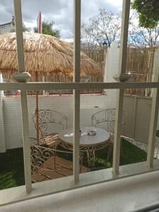 a view of a patio with a table and a straw hut at Nao Victoria in Gelves