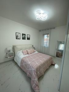 a bedroom with a large bed with a pink blanket at Casa M&N in Thiene