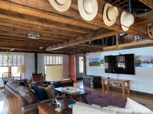 a living room with leather furniture and a flat screen tv at Magical Post And Beam Loft Downtown Newport! in Newport