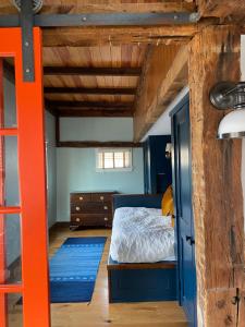 a bedroom with a bed with an orange frame at Magical Post And Beam Loft Downtown Newport! in Newport