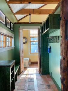 a bathroom with a toilet and a green wall at Magical Post And Beam Loft Downtown Newport! in Newport