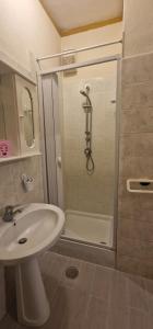 ein Badezimmer mit einem weißen Waschbecken und einer Dusche in der Unterkunft Casa Arancio in Tarquinia