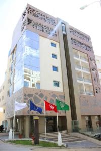 un bâtiment avec drapeaux devant lui dans l'établissement Samarons Hotels, à Tunis