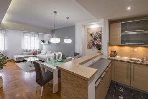 cocina y sala de estar con mesa y sofá en Apartment Marina, en Novi Sad