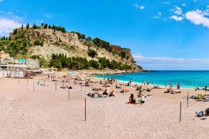grupa ludzi siedzących na plaży z oceanem w obiekcie L' Alto - 80m2, Grand Terrasse avec vue sur le Cap, à 200m des plages w Cassis
