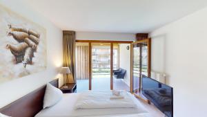 a hotel room with a bed and a balcony at Walensee House & Apartments in Unterterzen