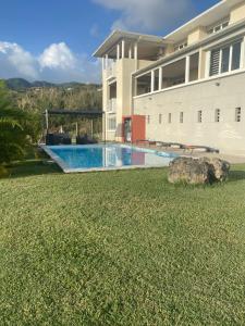 a swimming pool in front of a building at Villa Maxim vue sur mer in Fond Boucher