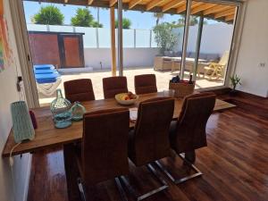 a wooden table with chairs and a dining room at Casa Playa Chica Lanzarote in Puerto del Carmen